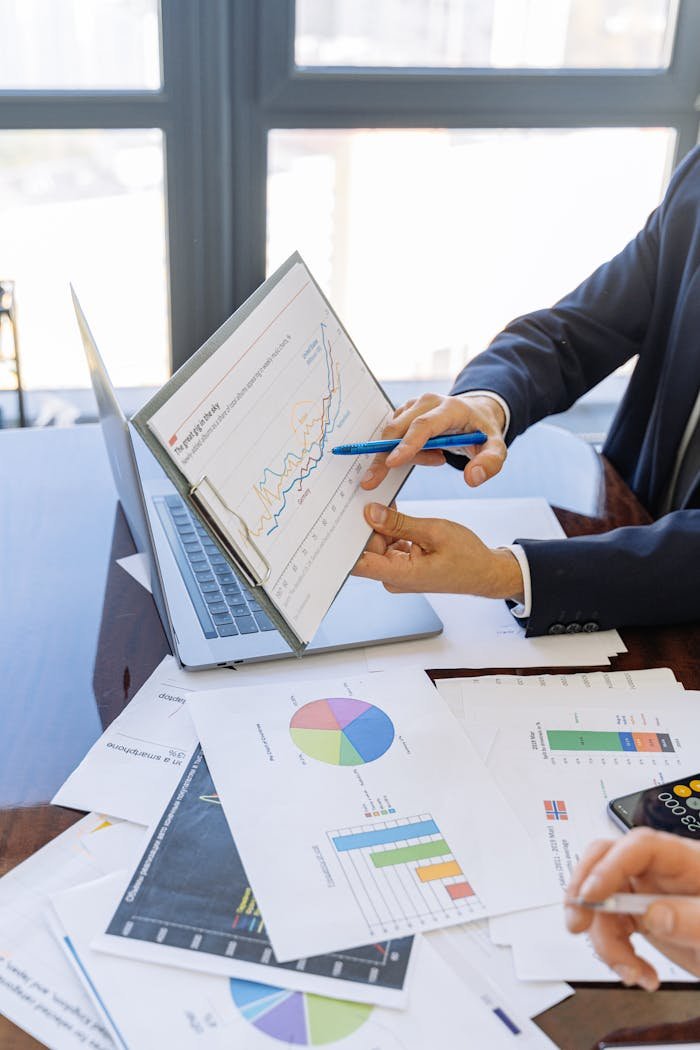 our-services-1 Business professionals discussing financial graphs and charts in an office setting.
