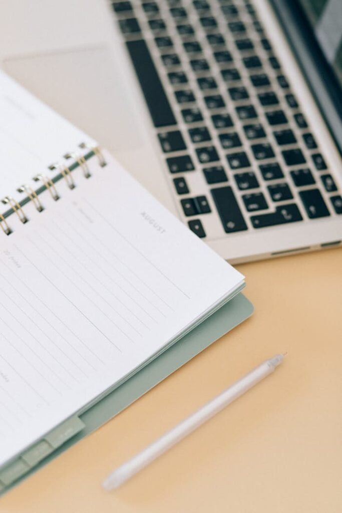 pexels photo 8062365 Open notebook next to a laptop and pen on a desk, ideal for business and planning.