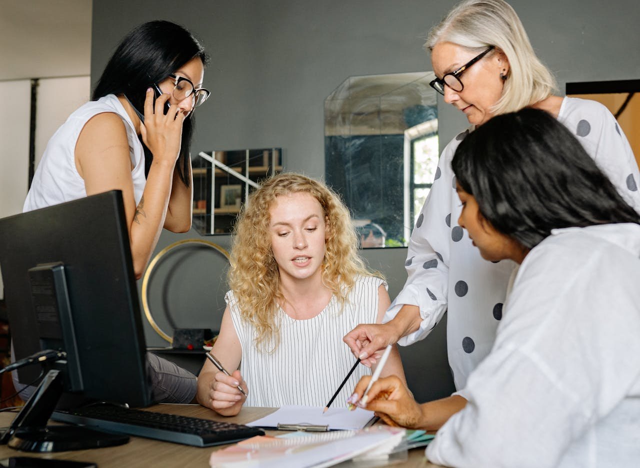 about-02 A diverse group of businesswomen engaged in a collaborative discussion at the office.